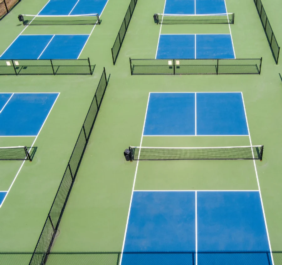 Pickleball players on a blue outdoor court